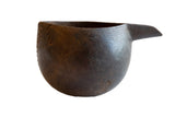 Antique African wooden pitcher with a rounded body and dark, textured wood finish.