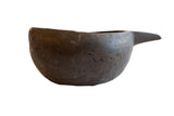 An antique African wooden pitcher with a dark, rustic finish and a distinctive spout.