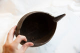 Detailed view of the antique pitcher's interior showing aged texture and stitched repairs.