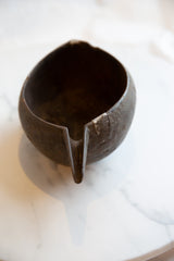 Looking down into the antique wooden pitcher, showing its rustic interior and spout.