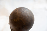 Detailed view of the antique pitcher's rich wood grain and textured, aged patina.