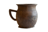 Antique handmade African wooden pitcher with dark brown patina and visible age-related character.
