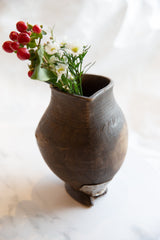 Hand-carved antique African wooden pitcher, displaying etched patterns and aged texture.