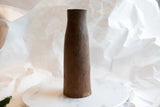 Handmade dark brown wood texture and aged patina on an antique African vase.