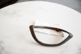 Angled view showing the handmade curved shape of the antique bronze artifact.