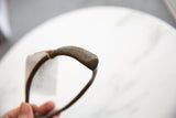 A close view of the rustic, hand-forged texture on the bronze artifact's tip.