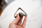 Antique African bronze artifact held to show its handmade feel and scale.