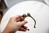 Vintage bronze bell cuff bracelet held in hand to show its scale and aged patina.