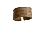 Antique African bronze cuff bracelet with a rich patina and textured geometric patterns.