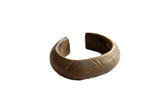 Antique African bronze cuff bracelet with etched geometric patterns and a time-softened patina.