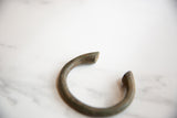 African bronze alloy manilla cuff with textured surface and ancient patina.