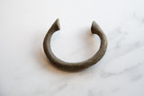 Handmade antique African bronze alloy manilla bracelet, C-shaped with pointed ends, rich patina.