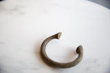 Close-up of the antique bronze alloy manilla cuff bracelet with textured patina.
