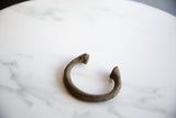 Antique African copper alloy manilla cuff showcasing its rich patina and aged texture.