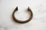 Close-up of the antique copper alloy bracelet's tapered end with rich patina.