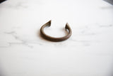 Textured copper alloy with time-softened patina on the antique manilla cuff.