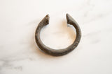 Aged patina on the pointed end of the antique African bronze manilla cuff bracelet.
