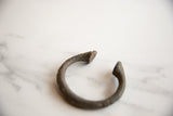 Detail of the collectible African bronze manilla bracelet, showcasing its handcrafted patina.