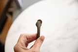 Collector's antique African bronze manilla, highlighting its textured surface and rich patina.
