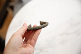 Antique African bronze alloy manilla cuff bracelet, highlighting its distinct rough texture and rich patina.