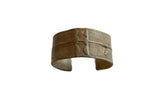 Antique African bronze cuff bracelet with detailed incised lines and raised motifs.