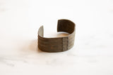 Angled profile of the antique African bronze cuff revealing its incised lines and aged patina.