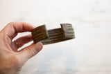 Profile view of the antique bronze cuff showing its substantial thickness and striped pattern.
