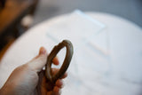 The substantial, curved form and twisted texture of an antique African bronze cuff.