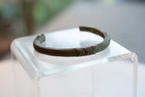 Etched geometric detailing and dark aged patina on an antique copper cuff bracelet.