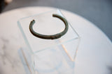 Angled view of the antique copper cuff highlighting its curved form and geometric detail.