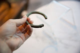 Showing the curved shape and time-worn patina of an antique copper cuff bracelet.