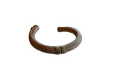 Antique African copper cuff bracelet with a dark patina and incised geometric detailing.