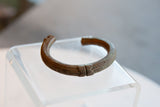 Hand-carved geometric motif and ribbed texture on an antique African copper cuff.
