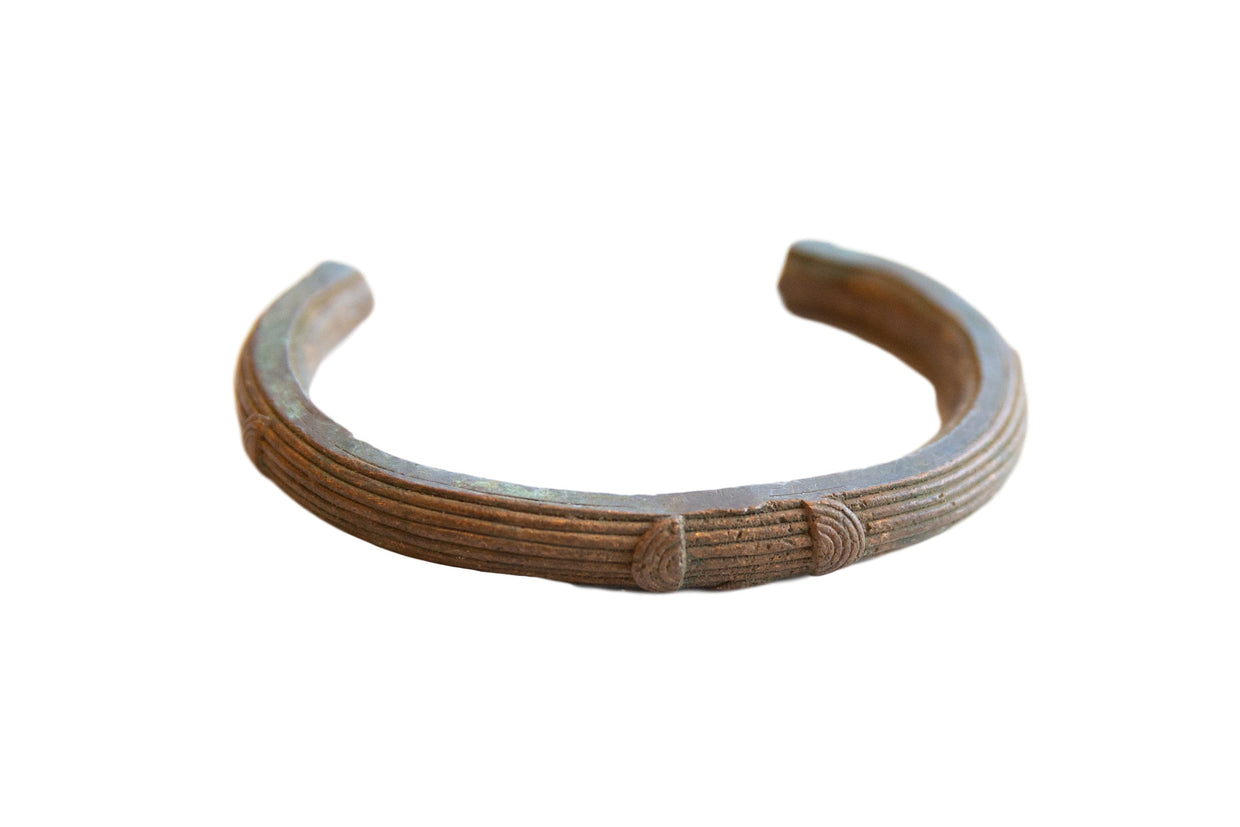 Antique African copper cuff bracelet with a rich patina and geometric line detailing.