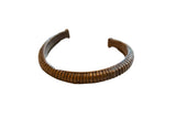 Antique African bronze cuff bracelet, hand-carved with a segmented pattern and time-softened patina.