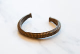 Antique African bronze cuff bracelet with a textured, ribbed surface and rich patina.