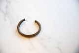 Antique African bronze cuff bracelet featuring its fine ribbed texture and aged patina.