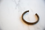 Segmented exterior and warm, aged patina on the antique African bronze cuff.