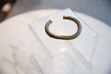Side profile of the antique bronze cuff showing its aged patina and notched geometric edge.