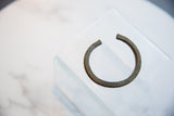 The circular shape and notched outer edge of a collectible antique bronze bracelet.