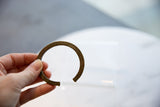 Collectible antique bronze cuff held in hand to show its wearable scale and patina.