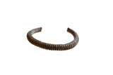 Antique African bronze cuff bracelet with a distinct ribbed pattern and a rich, dark patina.