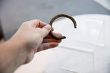 Antique striped bronze cuff held in hand, showing its textured patina and scale.