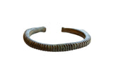 Antique African bronze cuff bracelet with a striped texture and aged patina.