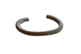 Antique African bronze cuff bracelet with a textured striped design and dark patina.