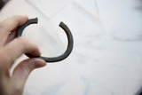 Antique African bronze bracelet showing its open cuff design and textured, patinated band.