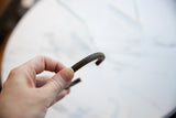 Antique African bronze cuff held to display its ridged texture and scale.