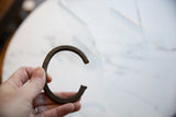 Antique African bronze cuff bracelet held in hand to show its scale and texture.