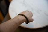 Antique African bronze cuff showing its striped texture as worn on a wrist.