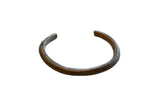 Antique African bronze cuff bracelet with a striped texture and aged patina.